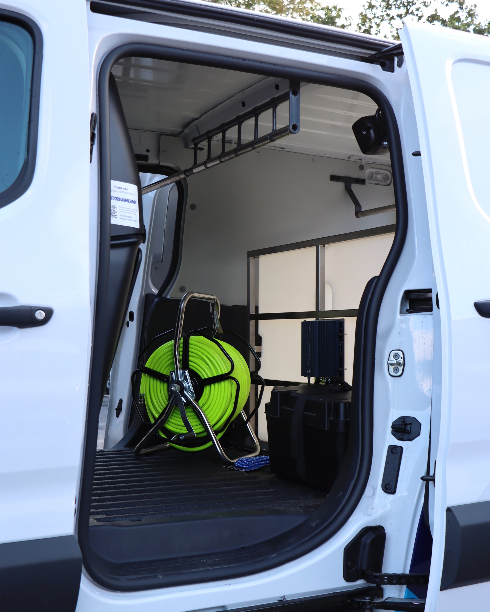 Compact van side-door fitout with lime hose reel and storage